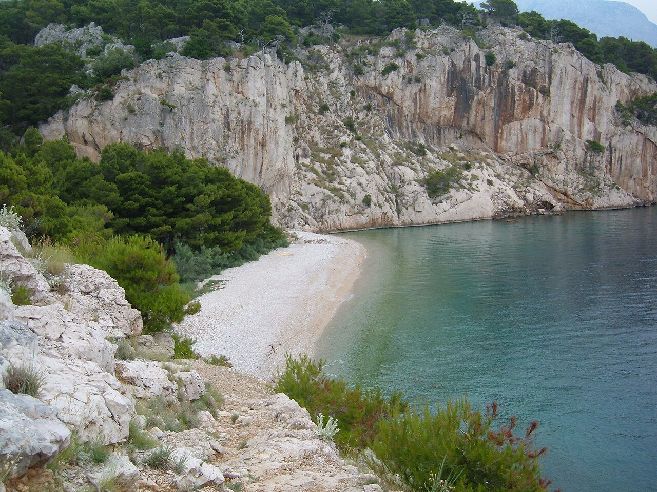 Nugal Beach beneath limestone cliffs and pine forest near Makarska